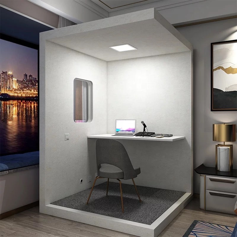Helle Bassaffine SOLID Aluminium-Plastic Vocal Booth in moderner Wohnung. Zeigt Arbeitsplatz mit Schreibtisch, Mikrofon und Laptop – ideal für Podcasts, Sprachaufnahmen oder konzentriertes Arbeiten mit hoher Schallisolierung.
